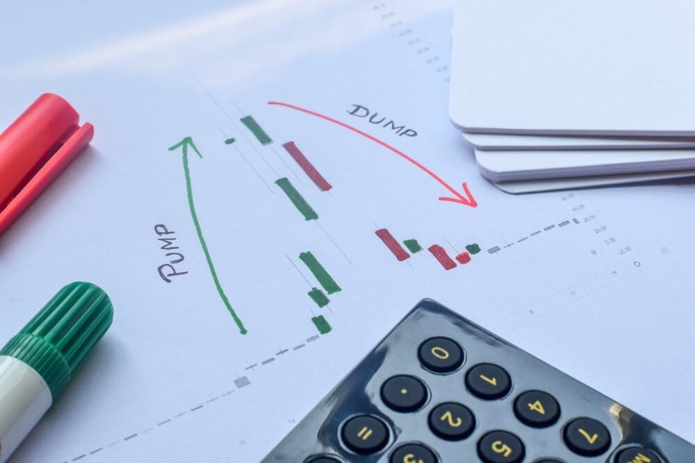 folha branca com escritos pump e dump lado a lado com setas nas cores verde e vermelho e símbolos do mercado financeiro